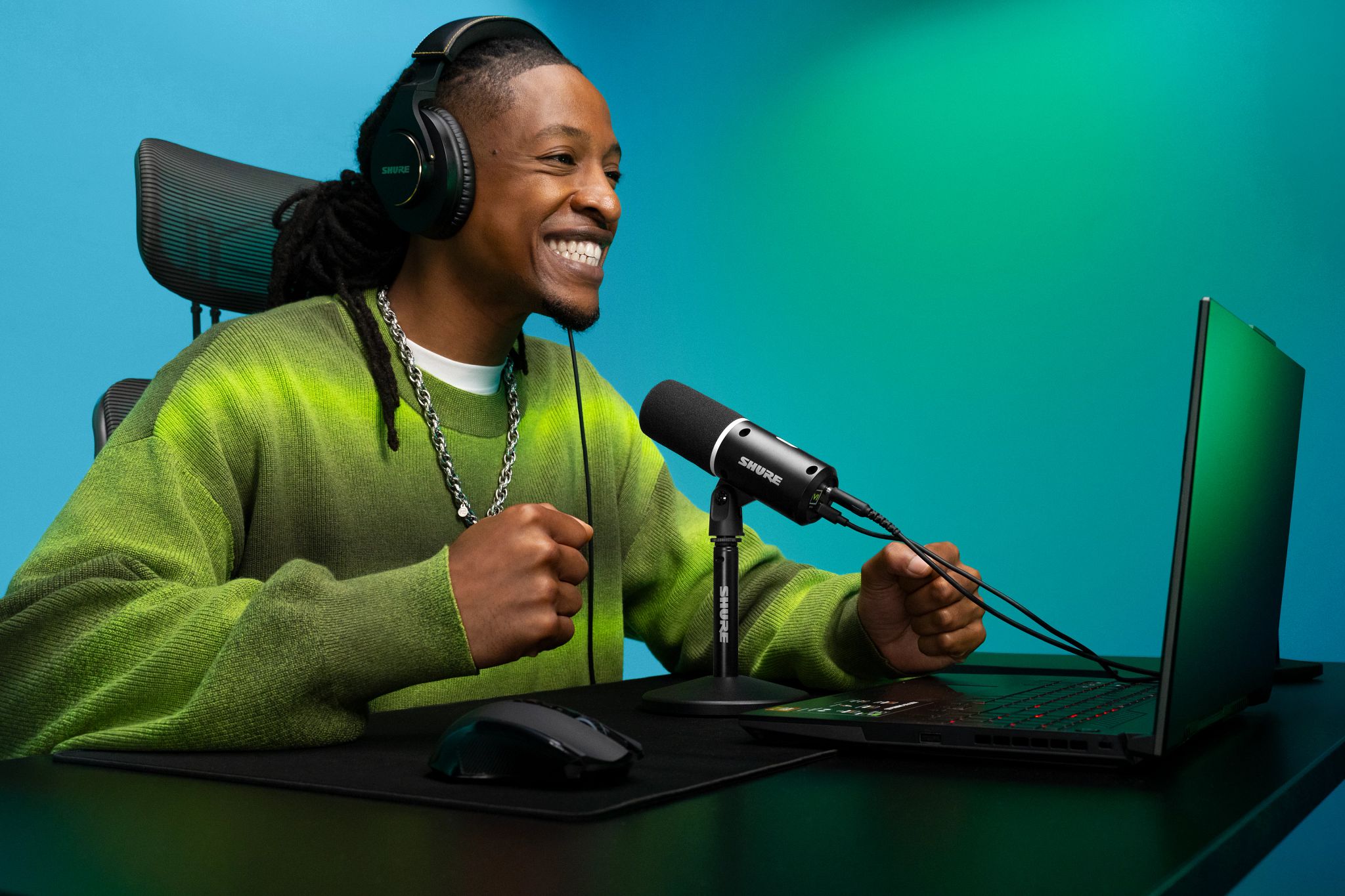 Microphone Shure MV6 Gen 2 noir sur son pied, utilisé avec un casque et un ordinateur portable.