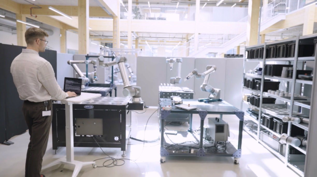 Un ingénieur face à quatre robots collaboratifs Universal Robots utilisés pour tester le standard MHS.