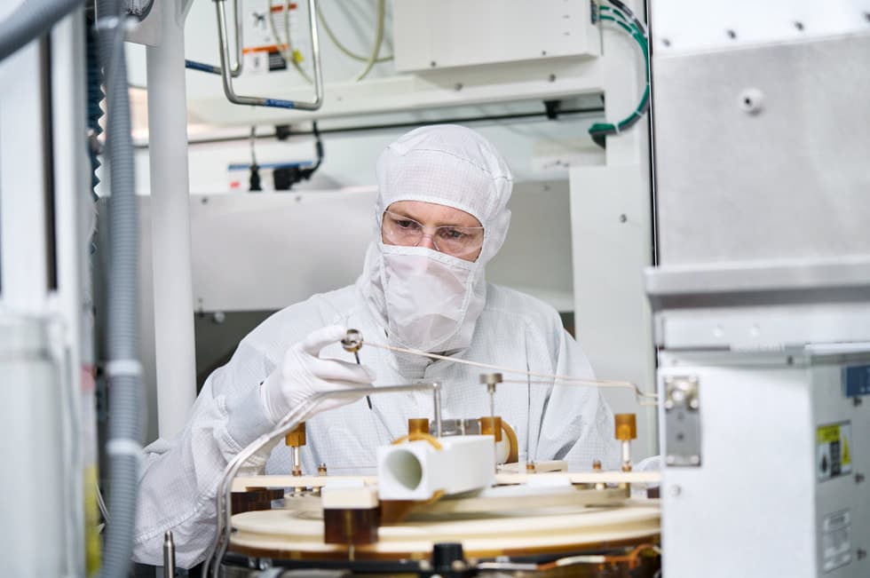 Photographie officielle Apple d’une technicienne en salle blanche dans une usine de semi-conducteurs américaine.