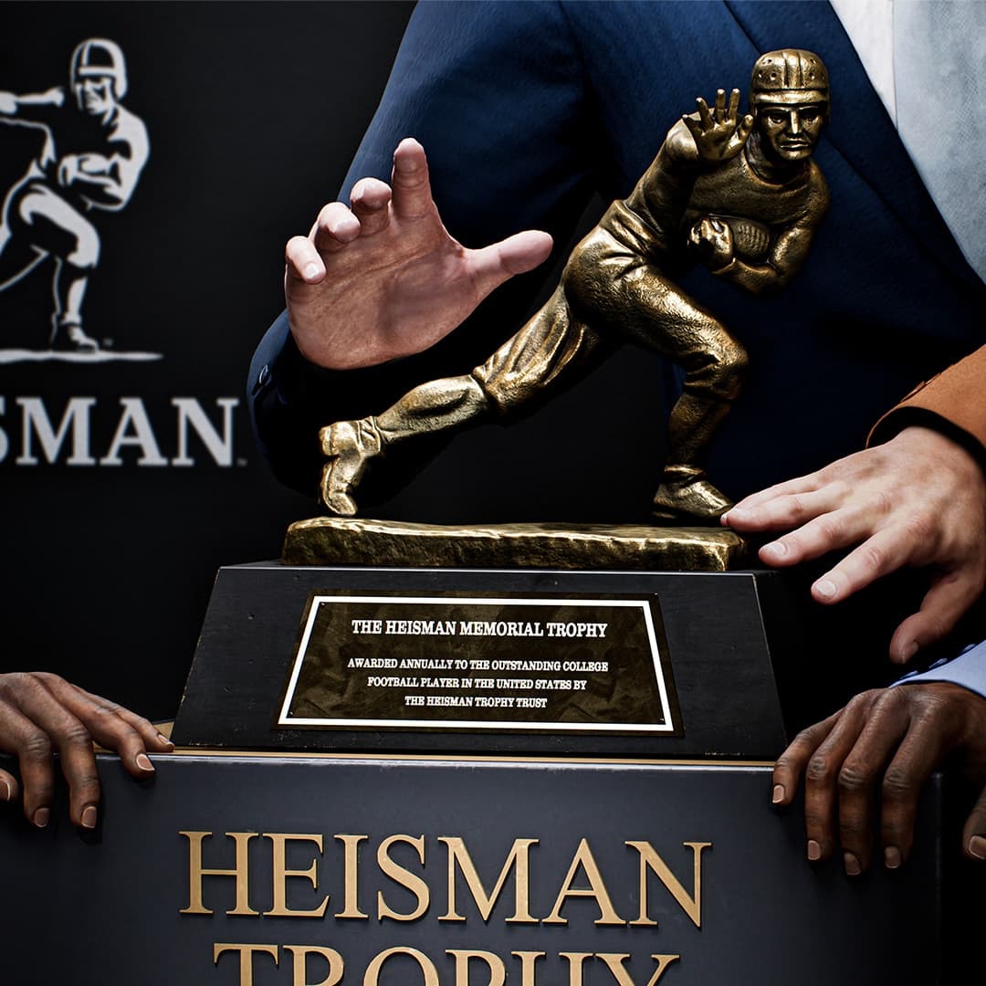 Image officielle de Road to Glory dans College Football 27 montrant le trophée Heisman lors d’une cérémonie.