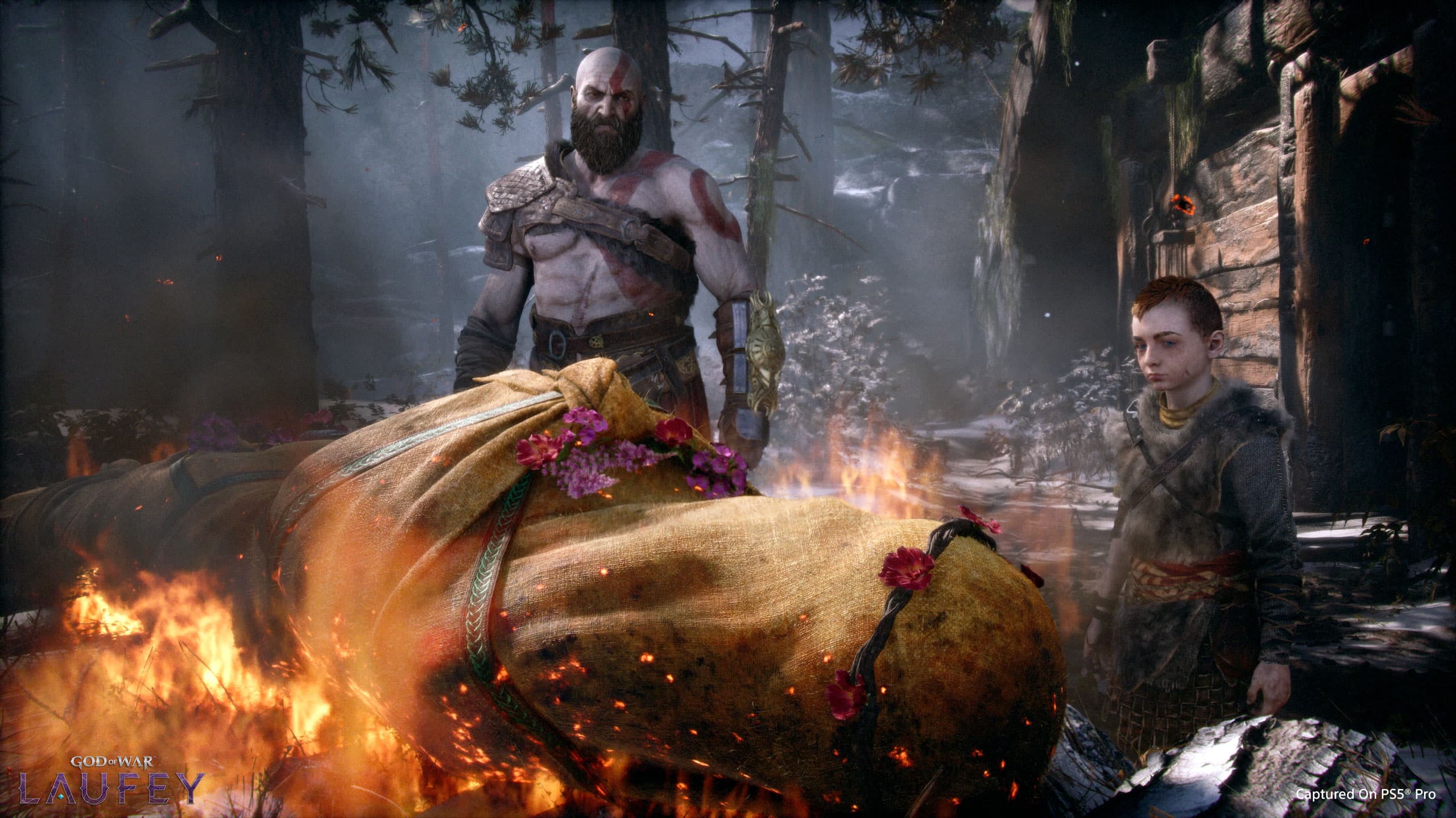 Kratos et Atreus se tiennent devant le corps de Faye pendant ses funérailles dans une capture officielle de God of War Laufey.