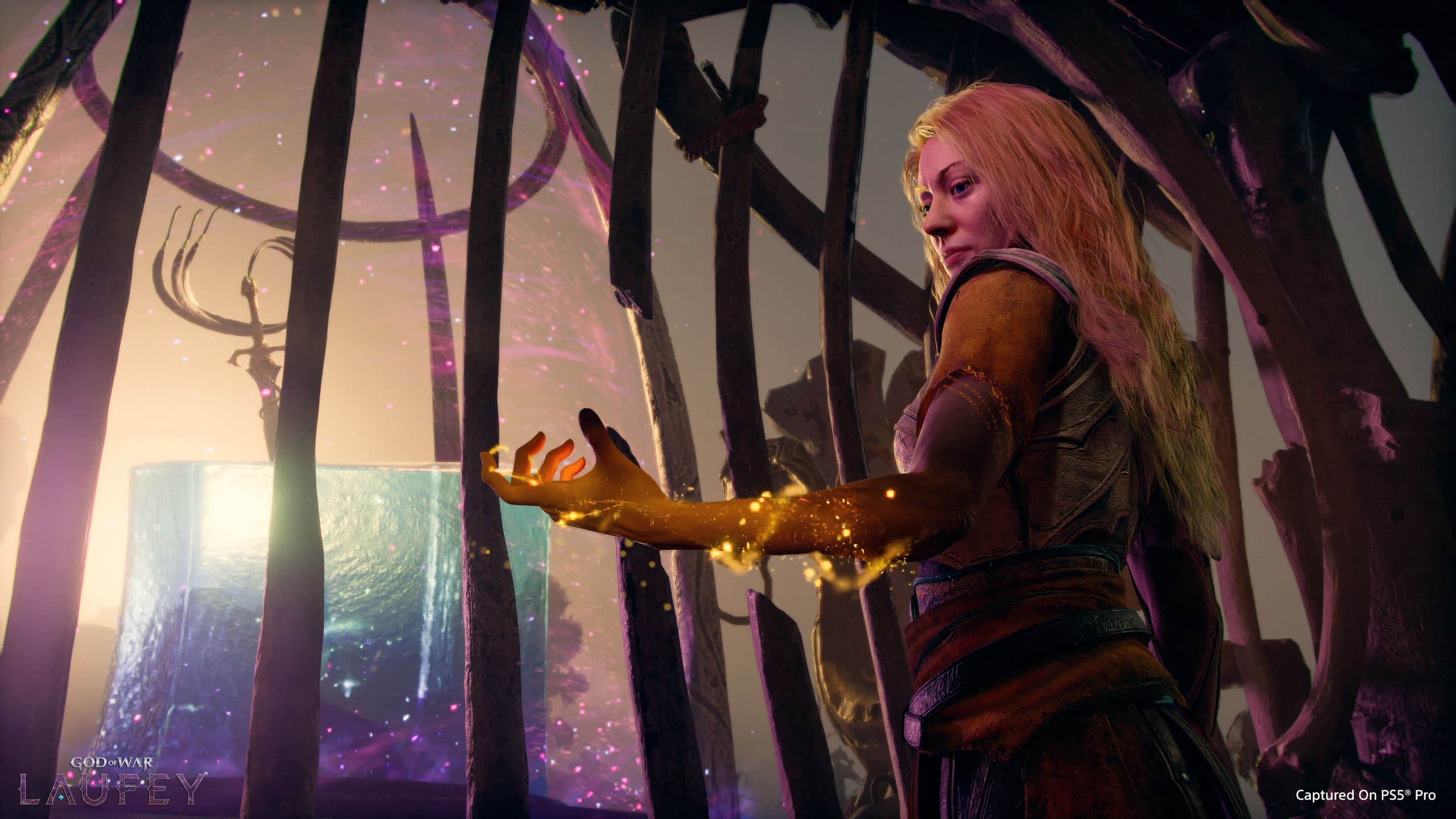 Faye manipule une énergie dorée devant un cube lumineux dans une capture officielle de God of War Laufey.
