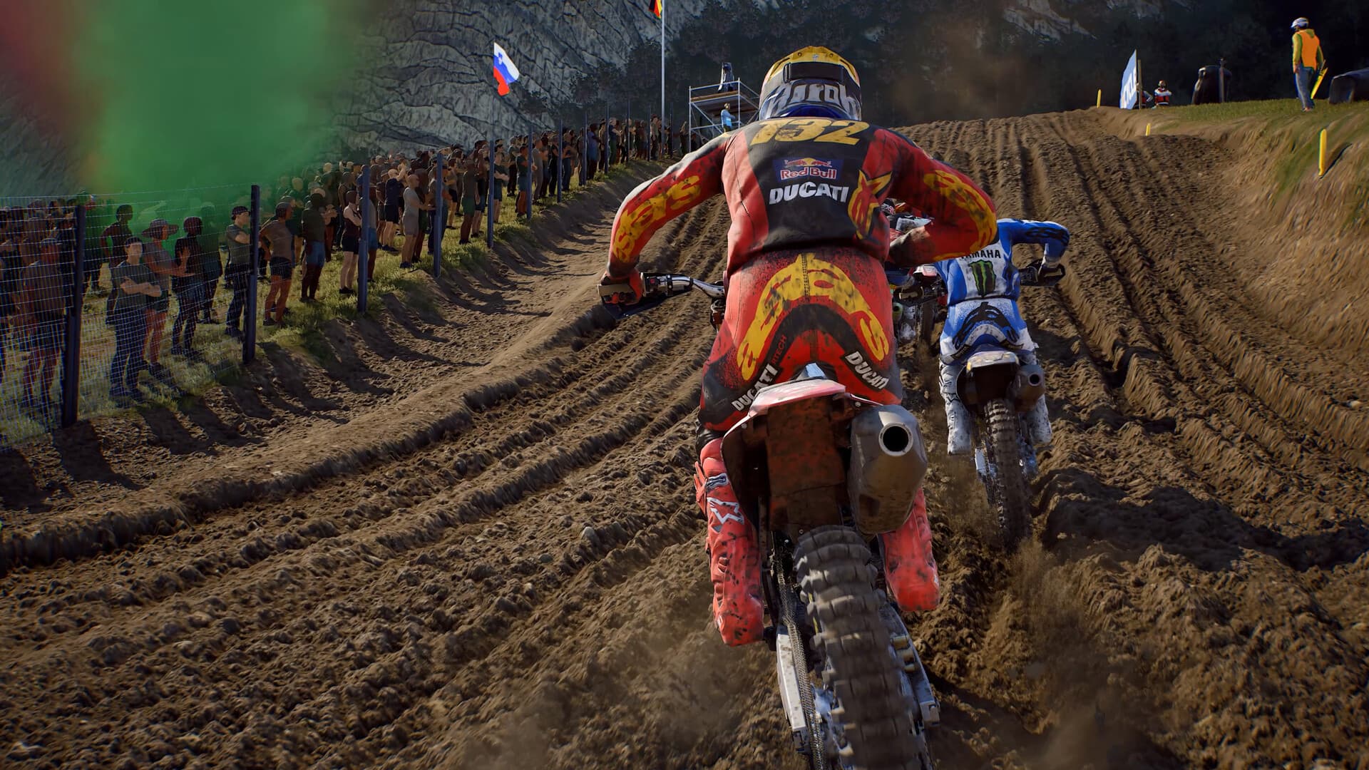 Capture officielle de MXGP 26 en vue arrière montrant deux motos progresser dans une montée profondément marquée.