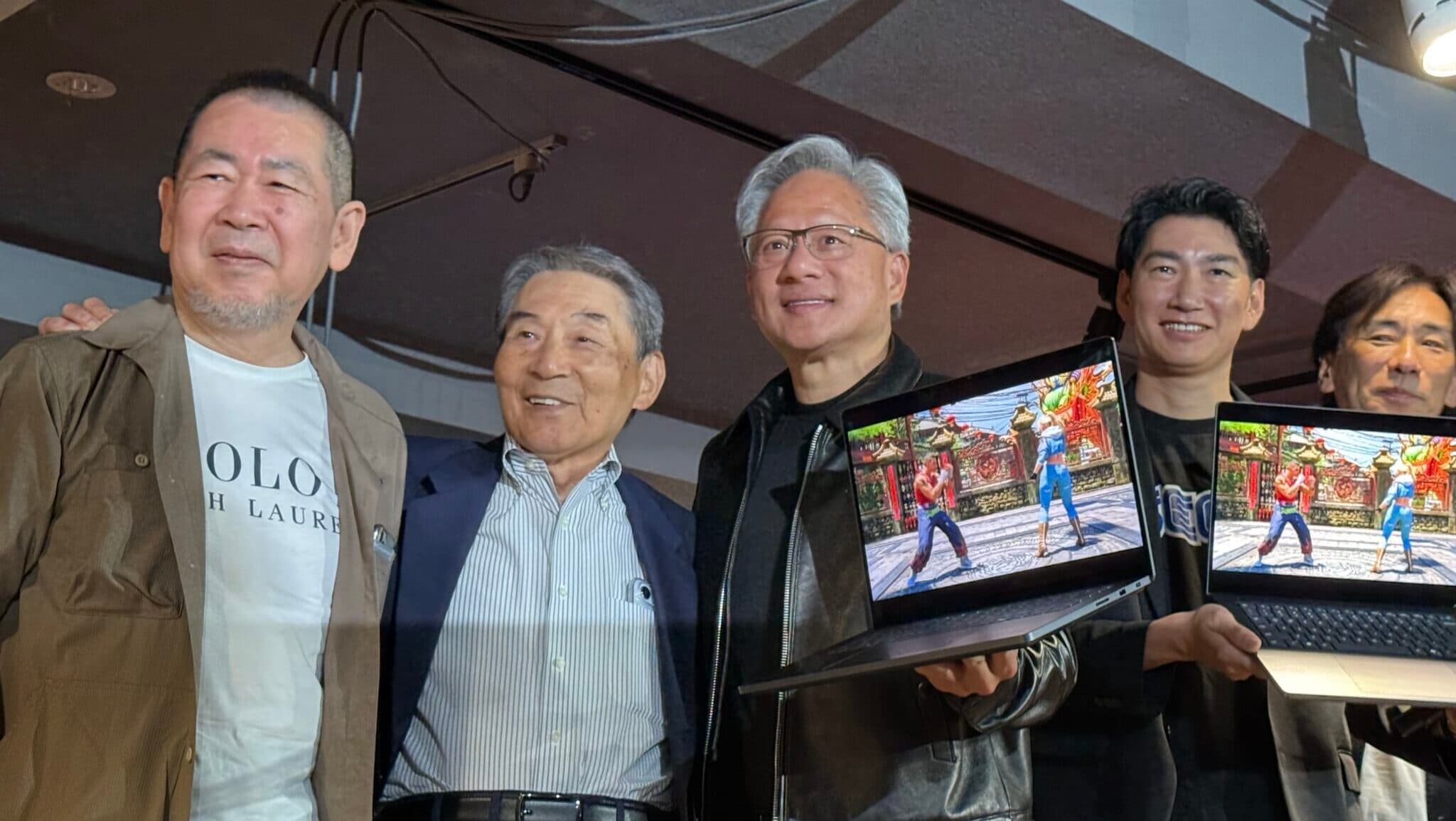 Jensen Huang et des responsables historiques de Sega présentent Virtua Fighter sur deux PC portables RTX Spark à Tokyo.