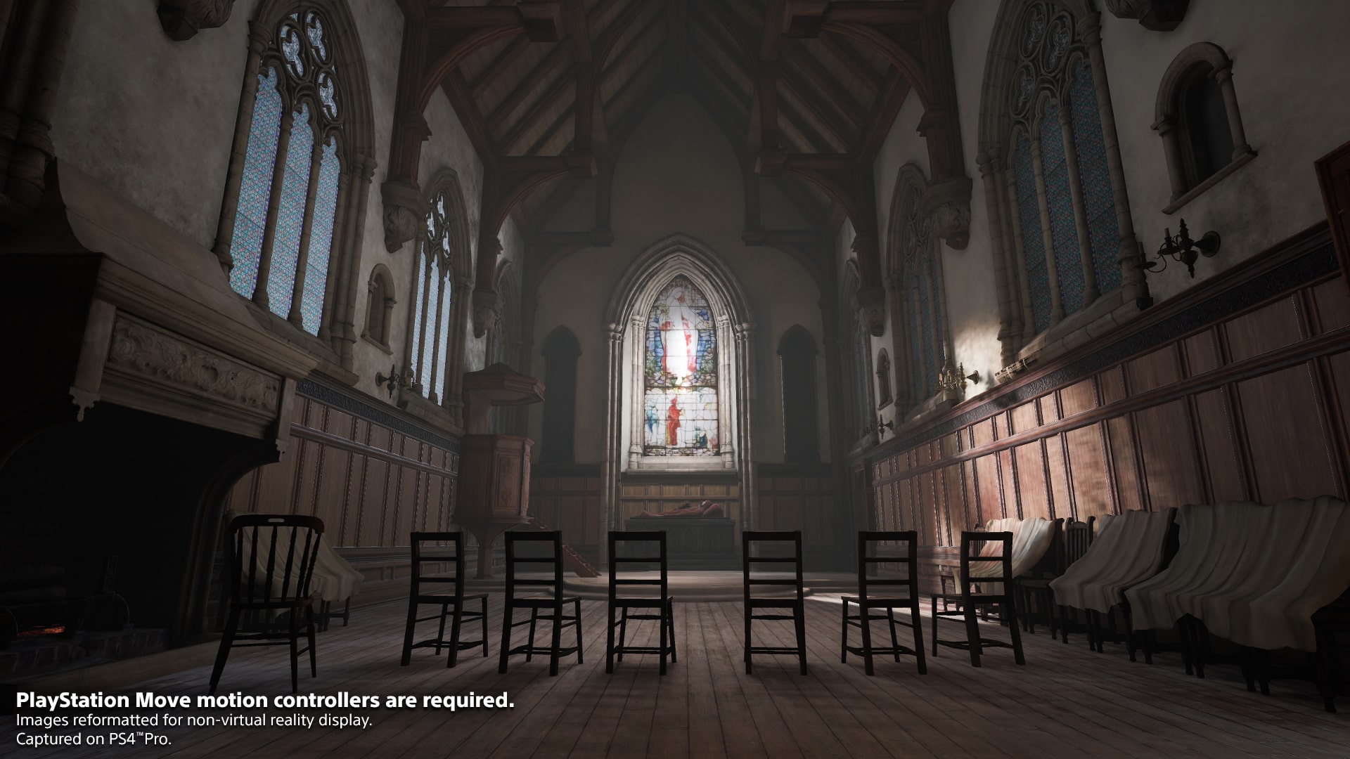 Des chaises sont disposées dans une grande salle éclairée par des vitraux.