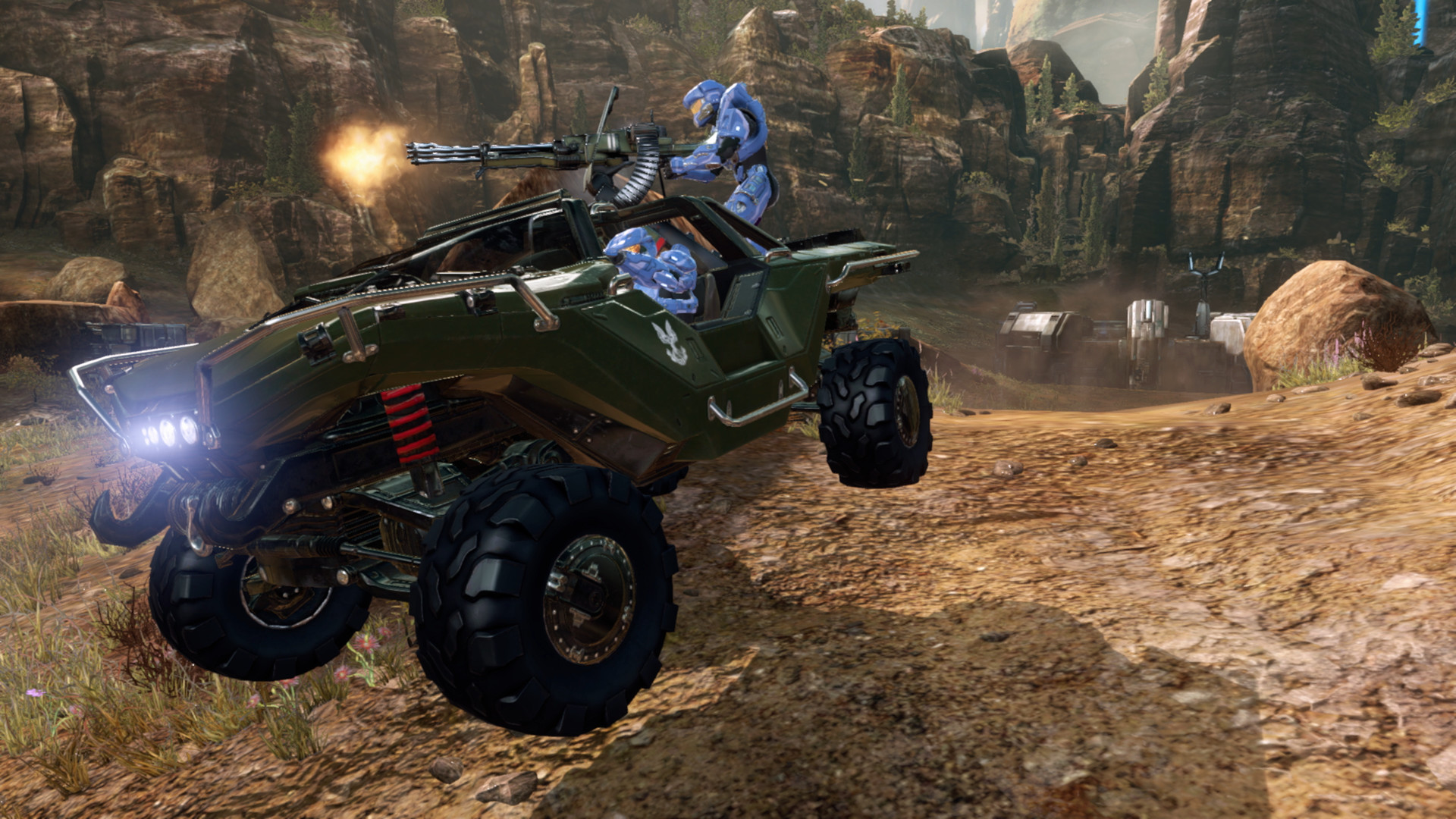 Multijoueur Anniversary de Halo 2 dans MCC : un Warthog avec des Spartans bleus franchit un relief rocheux.