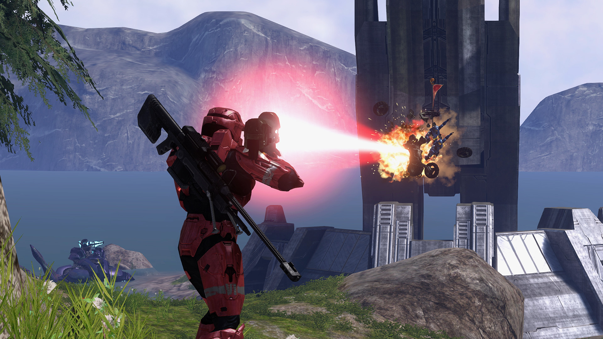 Halo 3 dans MCC : un Spartan rouge tire au laser vers un adversaire près d’une tour au bord d’un lac.