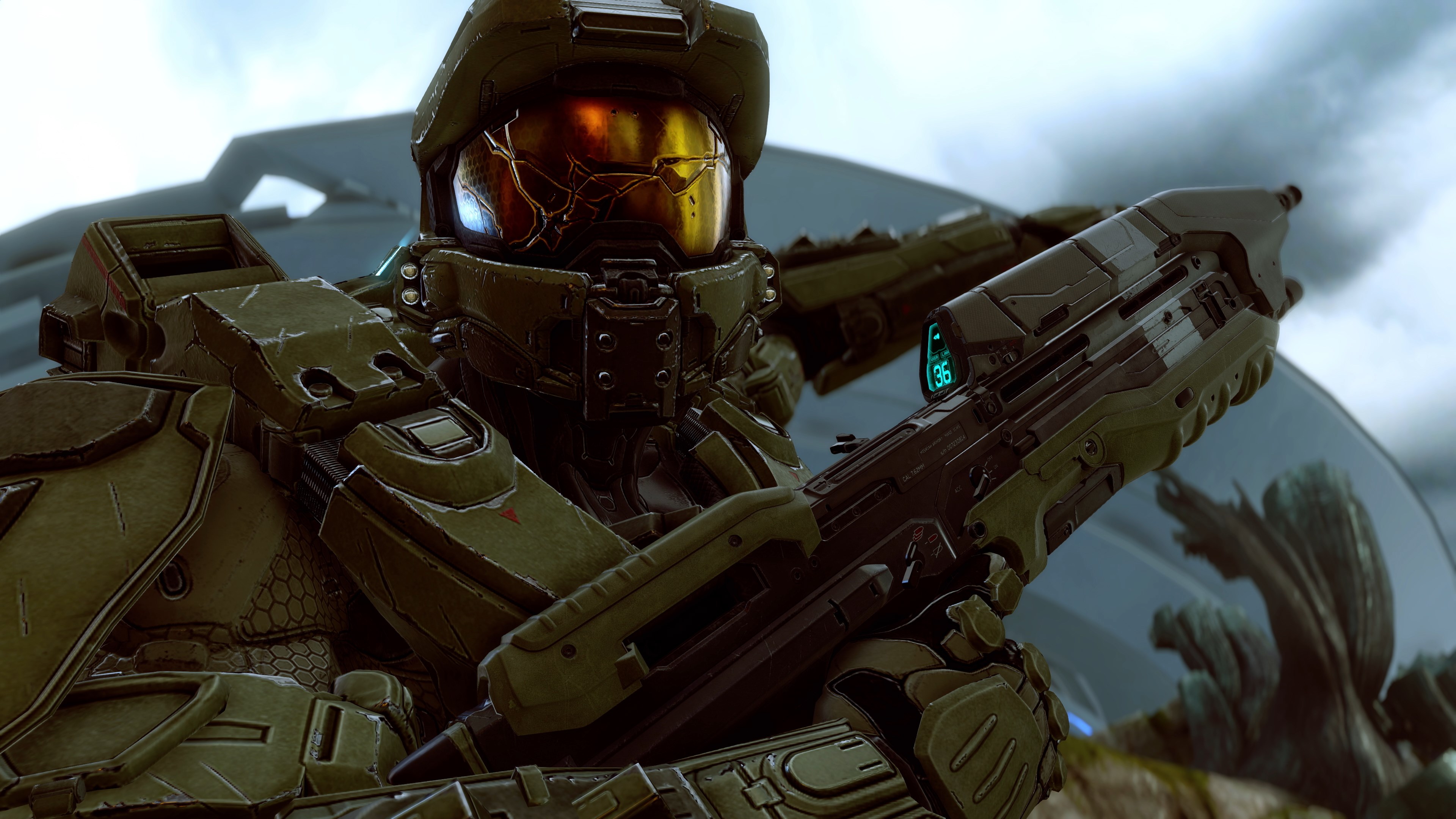 Le Major, en armure verte, tient son fusil d’assaut devant une structure futuriste.