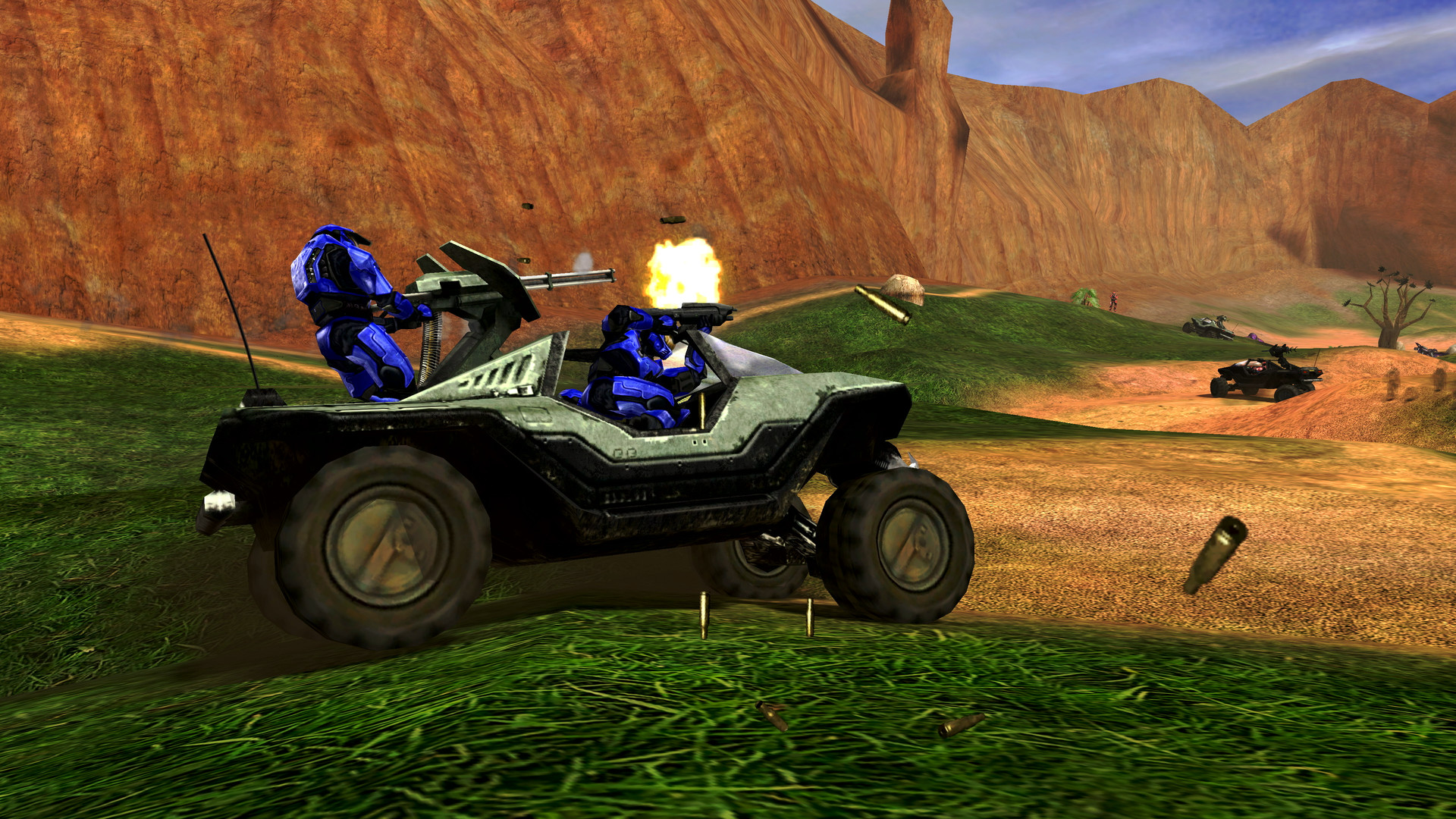 Multijoueur de Combat Evolved dans MCC : des Spartans bleus parcourent un canyon verdoyant à bord d’un Warthog.