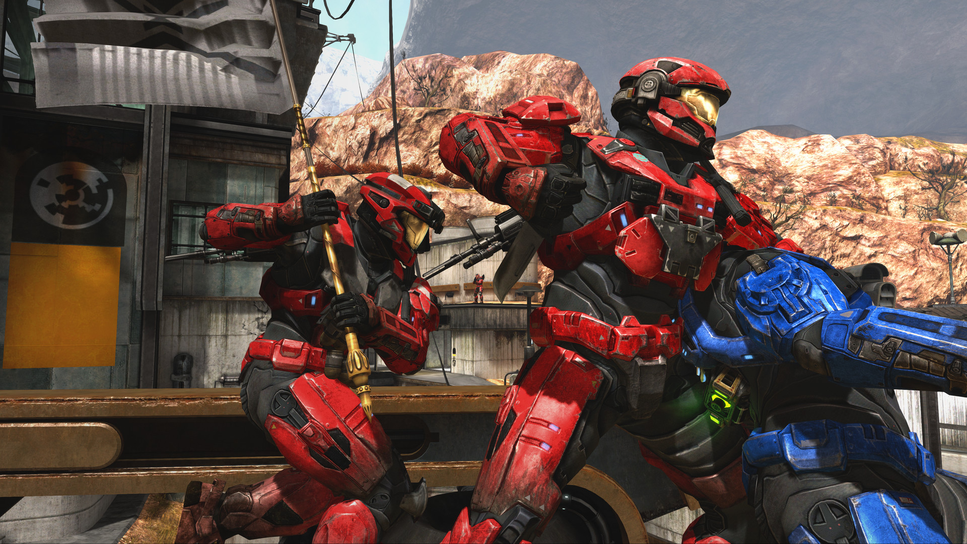 Halo: Reach dans MCC : deux Spartans rouges équipés d’armes différentes près d’une installation désertique.