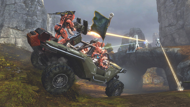 Multijoueur de Halo 4 dans MCC : un Warthog transporte des Spartans rouges dans une vallée rocheuse.