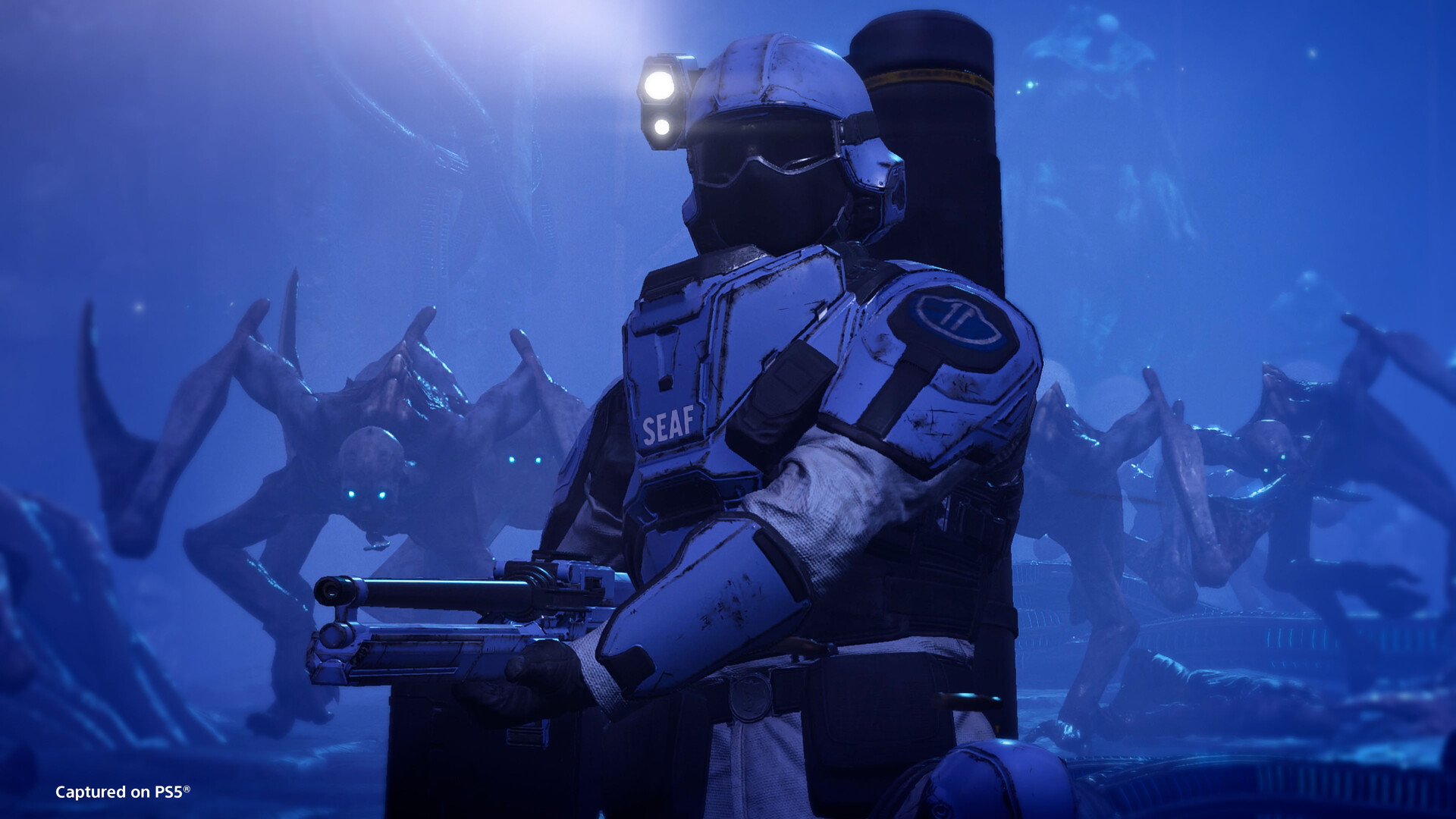 Un soldat de la SEAF se tient devant des constructions éclairées de bleu.