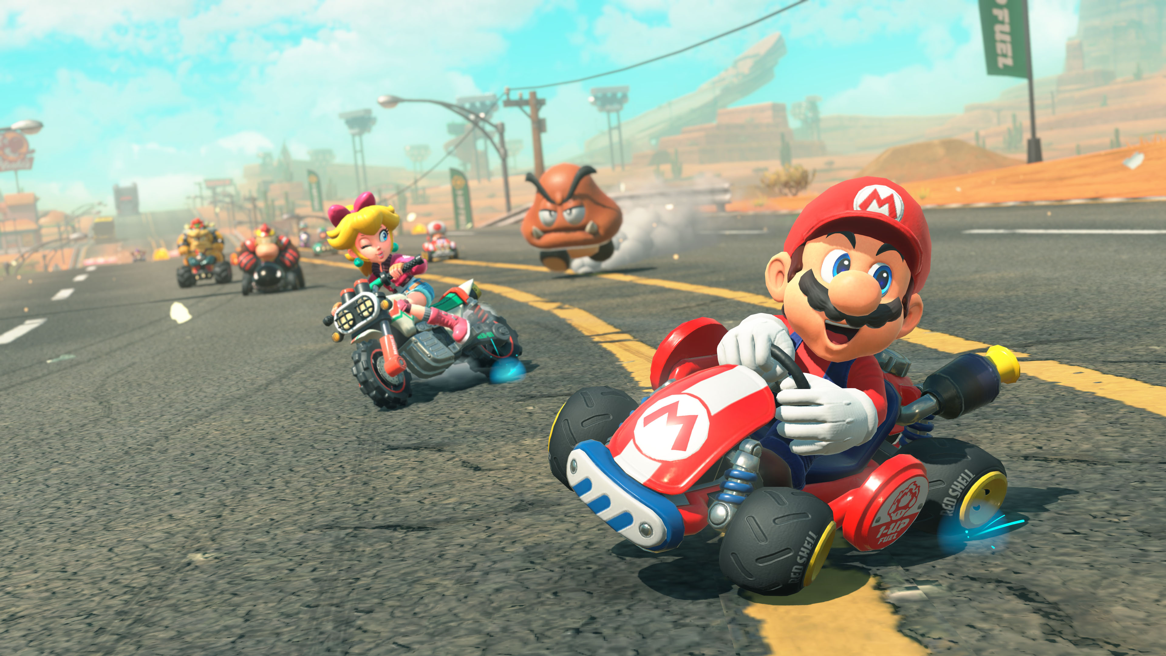 Mario et d’autres pilotes roulent sur un circuit désertique.
