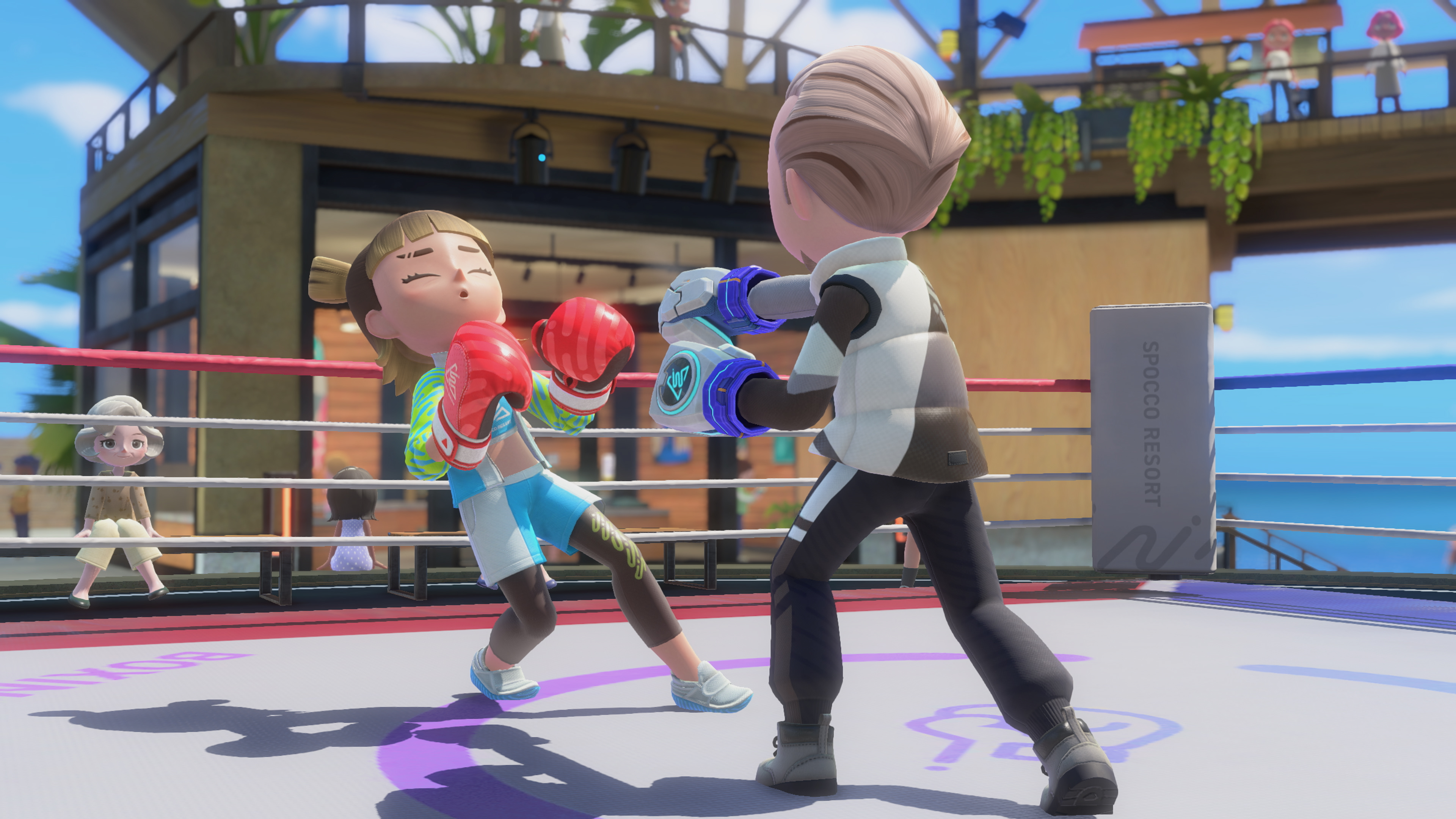 Combat de boxe sur un ring en plein air.