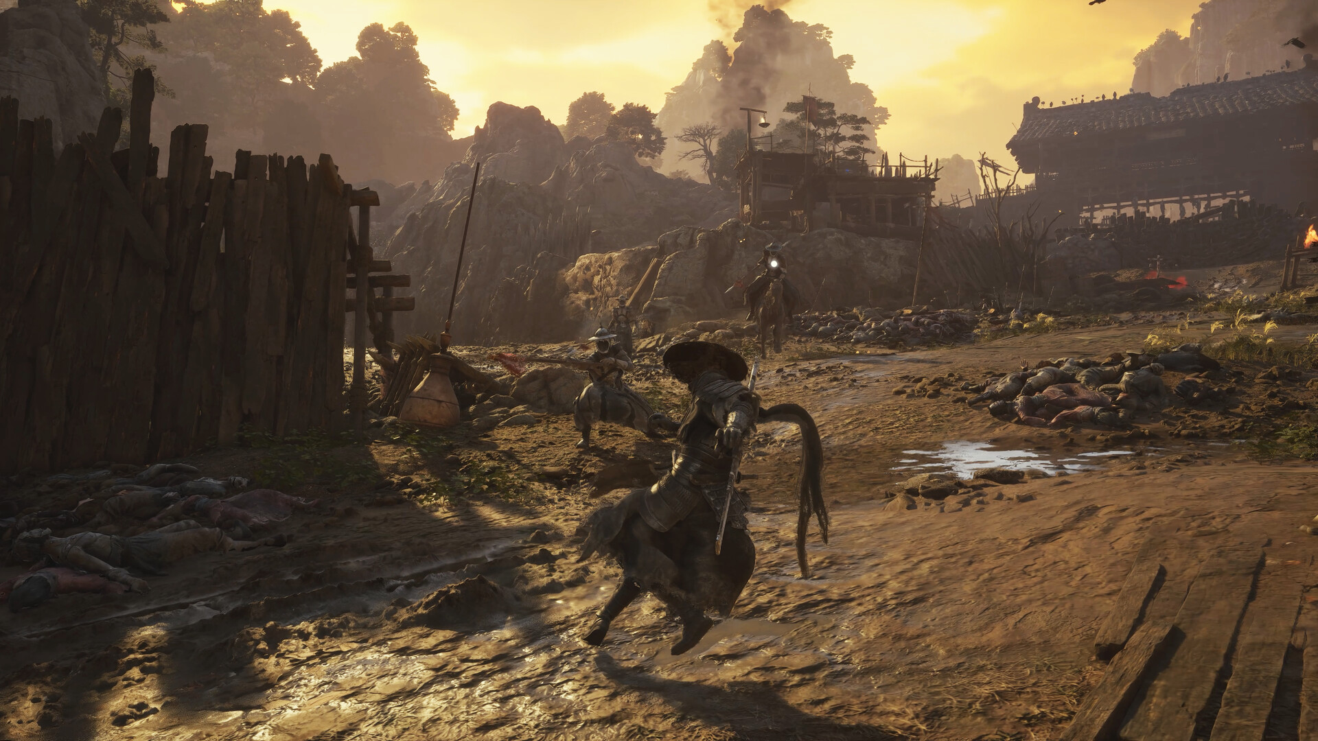 Un personnage traverse une zone fortifiée au soleil couchant.