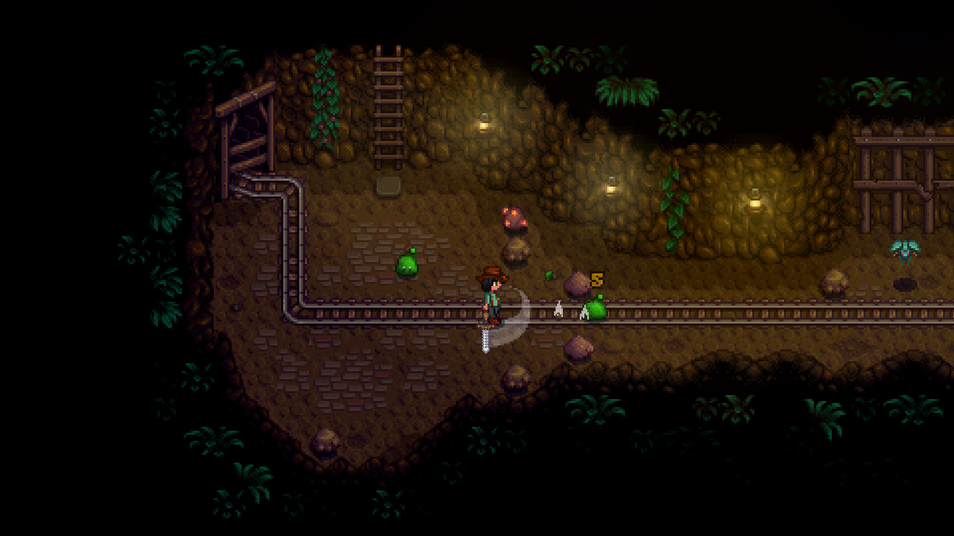 Un personnage explore une mine avec rails et rochers.