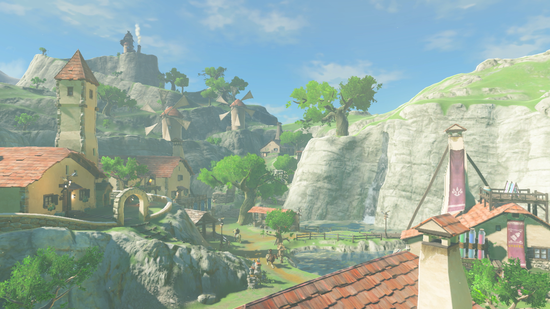 Vue d’un village installé entre des falaises verdoyantes.