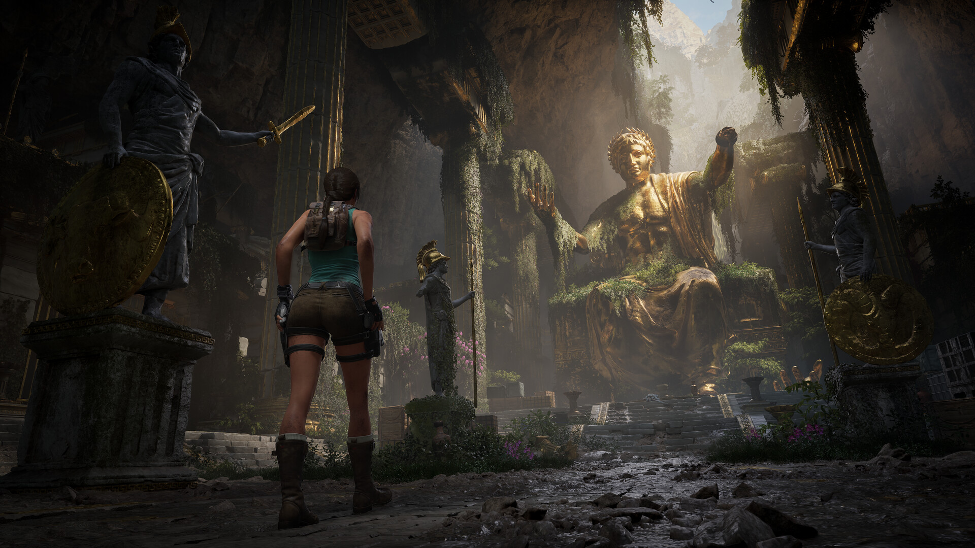Lara Croft observe de grandes statues dans des ruines.