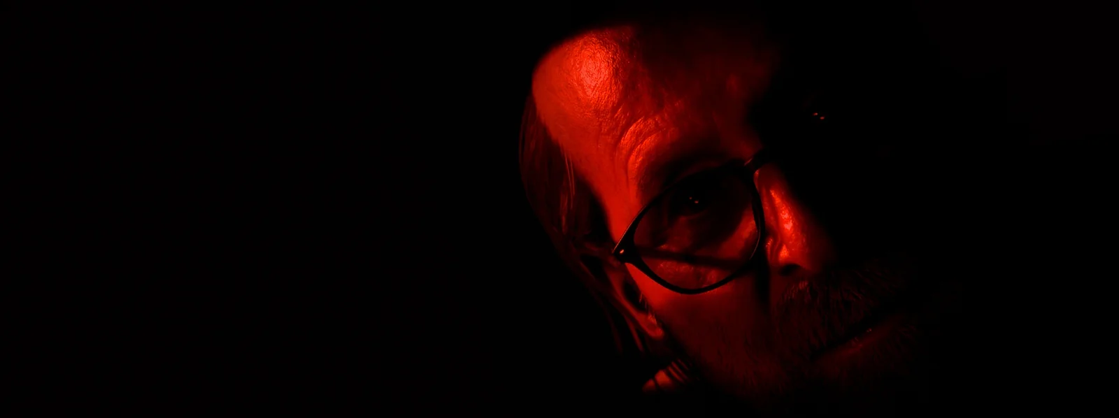 Key art officiel d’Until Dawn 2 montrant le Dr Hill éclairé en rouge